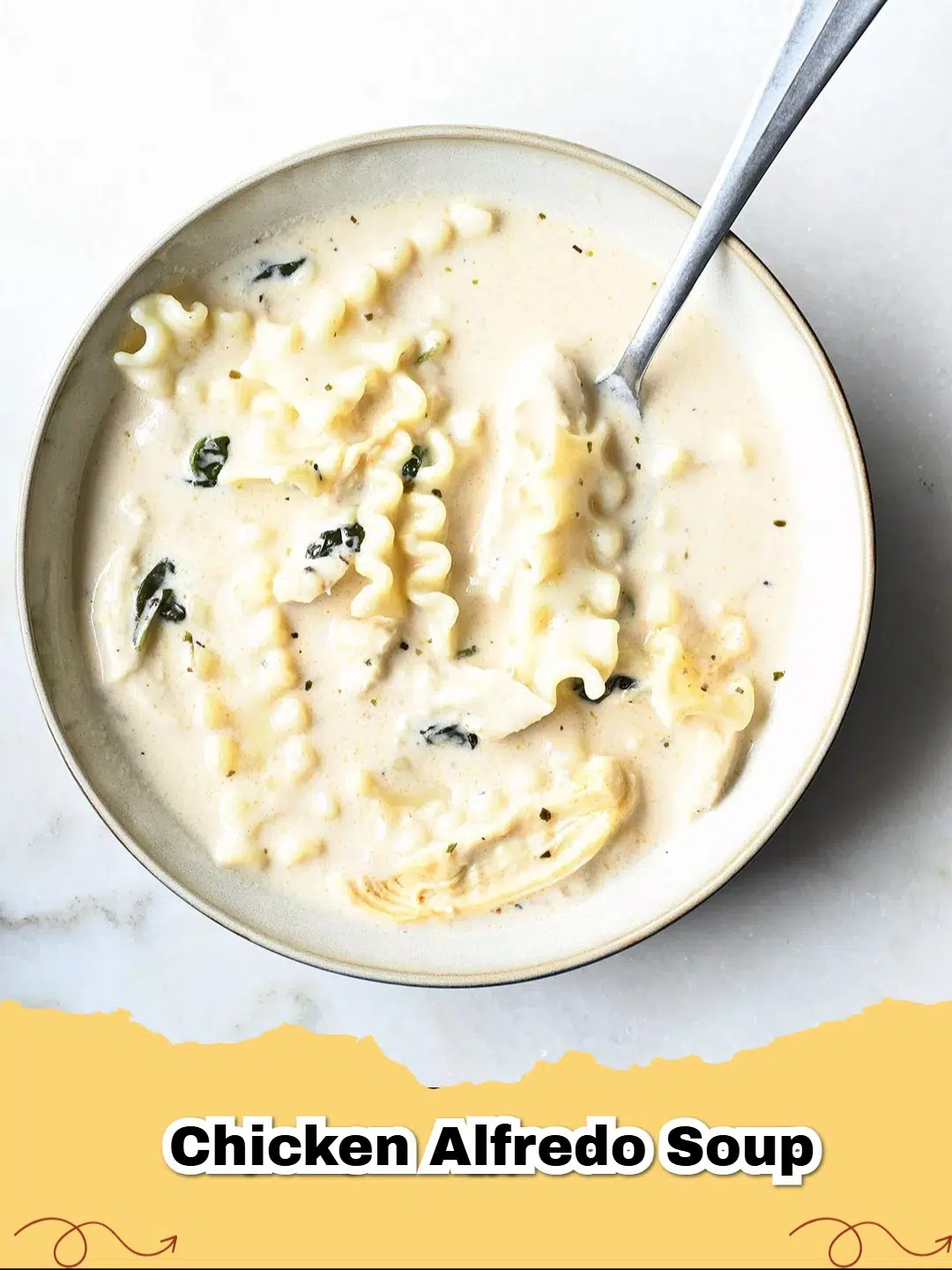 A steaming bowl of creamy chicken alfredo soup with pasta and parsley garnish, perfect for comfort food.