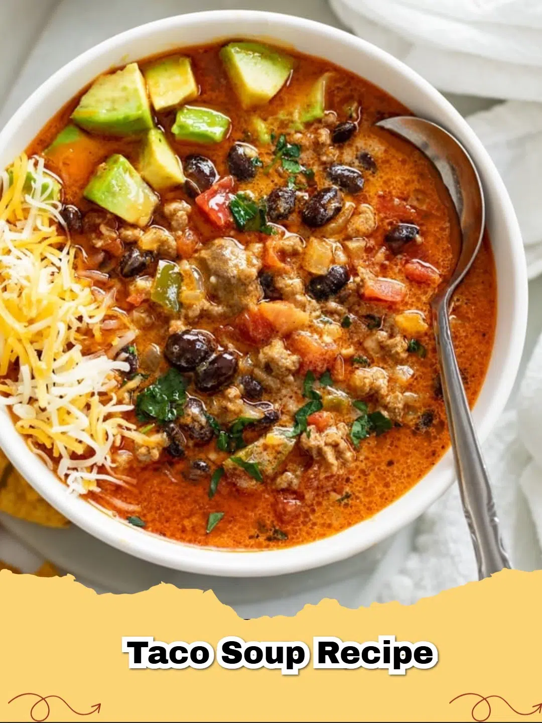 A hearty bowl of creamy ground beef taco soup topped with shredded cheese and cilantro, perfect for dinner.