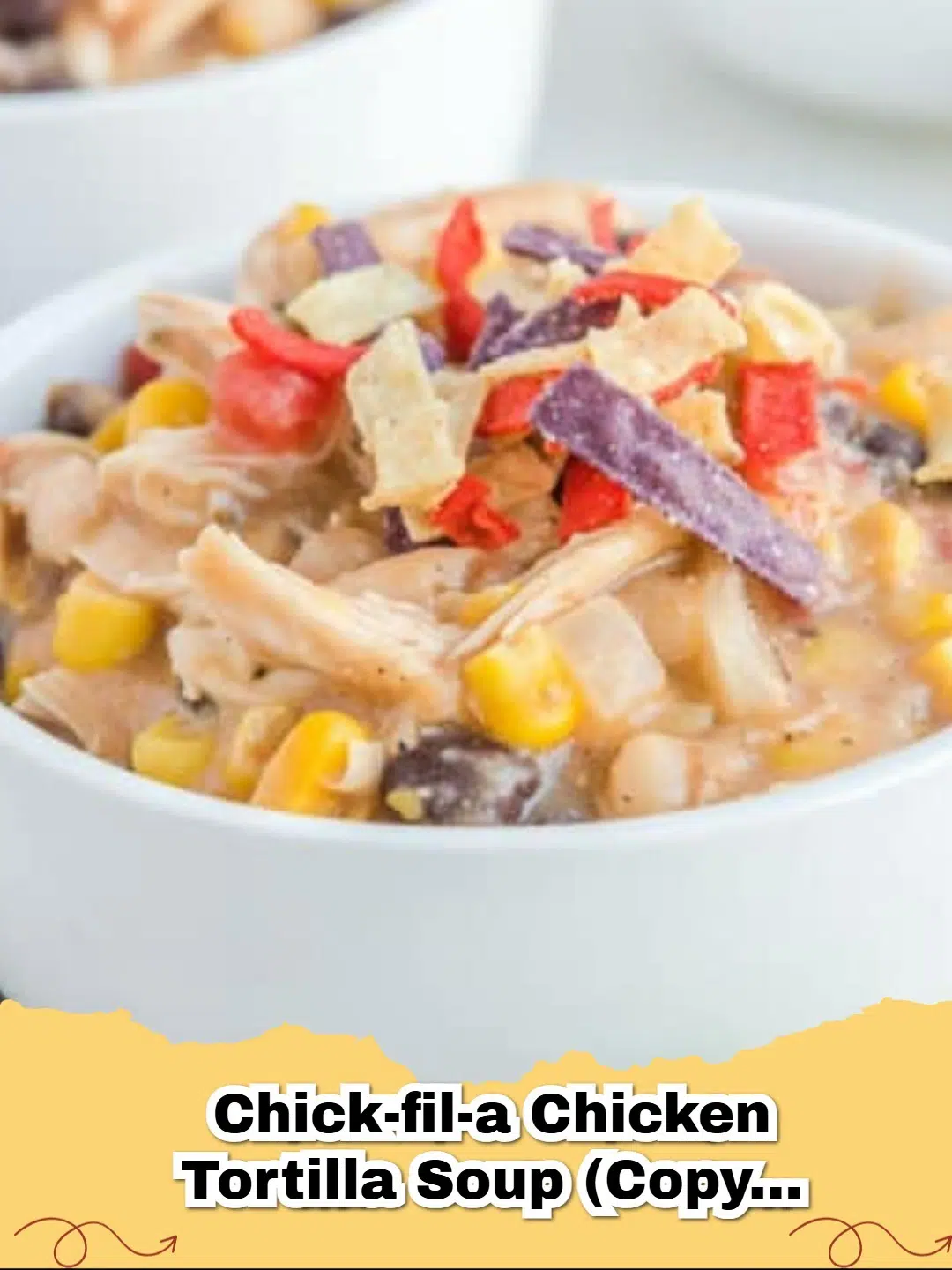 A bowl of hot Easy Copycat Chick-fil-A Chicken Tortilla Soup topped with tri-color tortilla strips and a lime wedge.