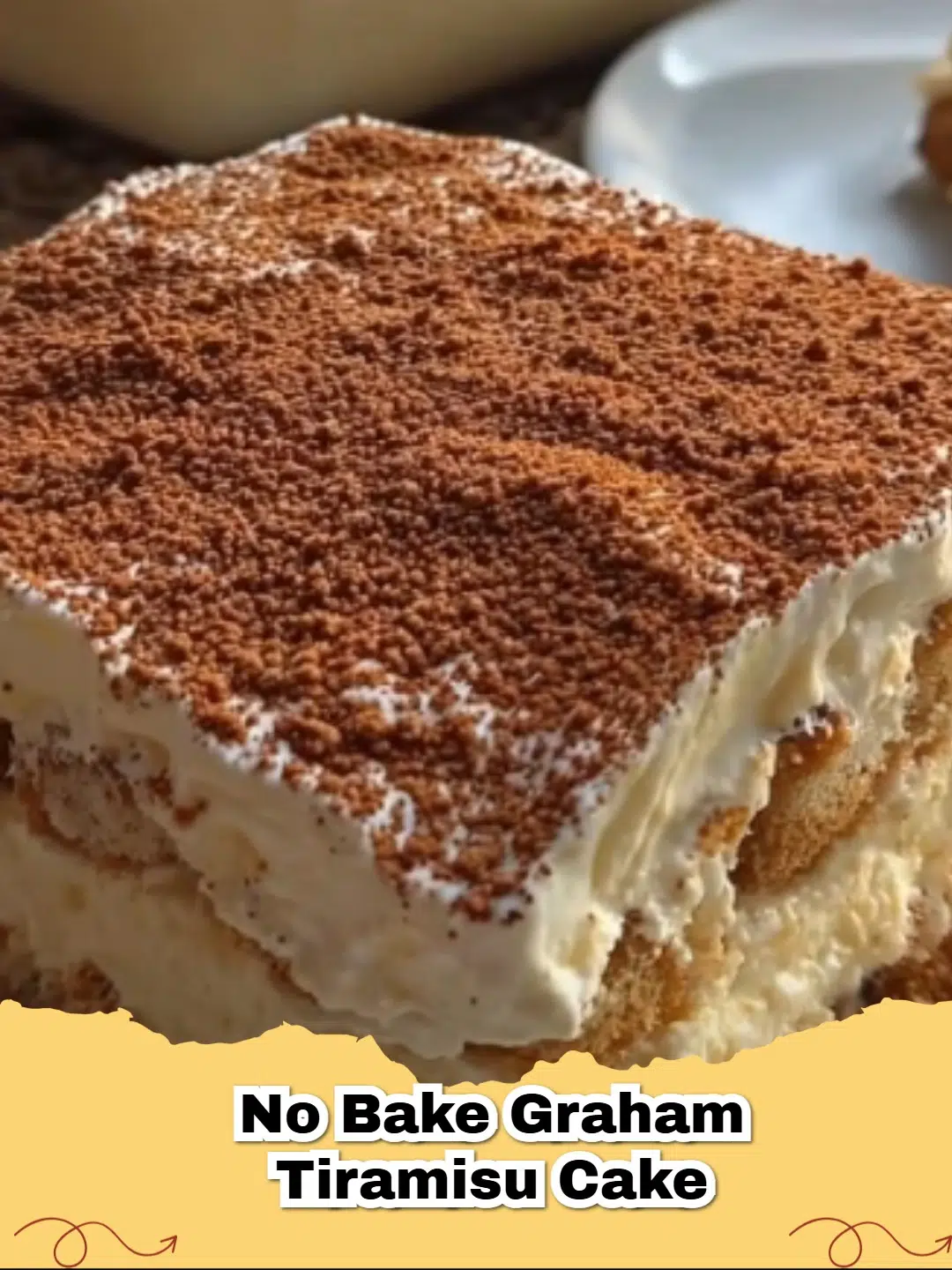 A square dish filled with a beautifully layered No-Bake Graham Tiramisu Cake, dusted with cocoa powder.