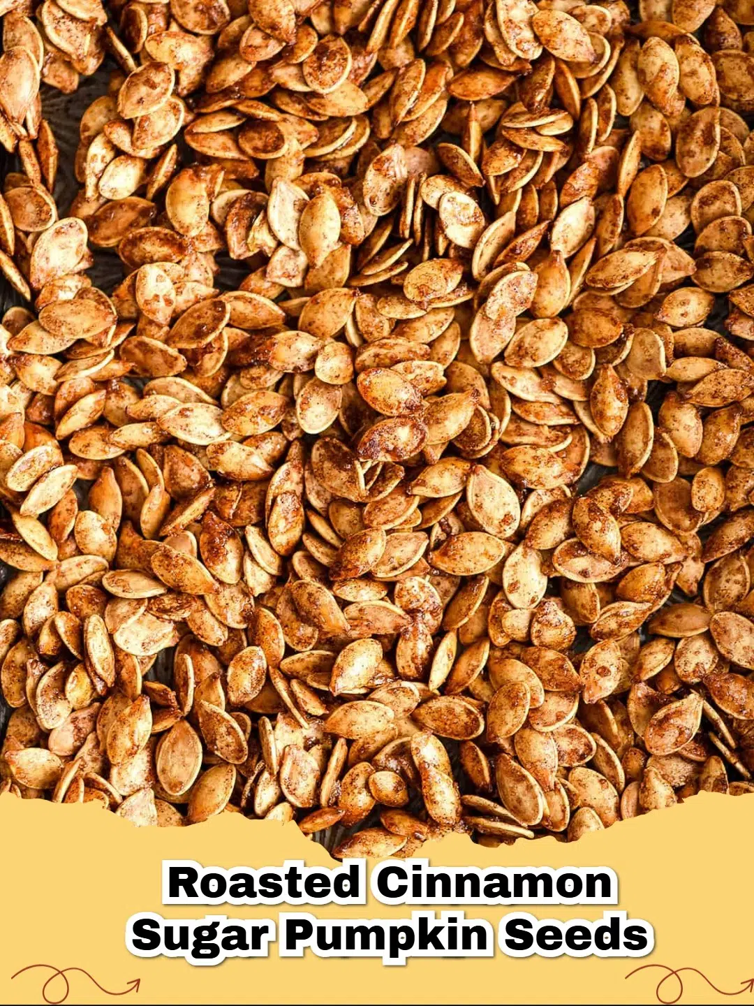Close-up of golden brown easy roasted cinnamon sugar pumpkin seeds on a baking sheet, ready to eat.