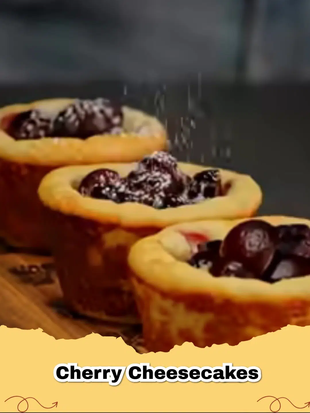 A close-up of a mini cherry cheesecake with a graham cracker crust and a dollop of whipped cream on top, ready to eat.