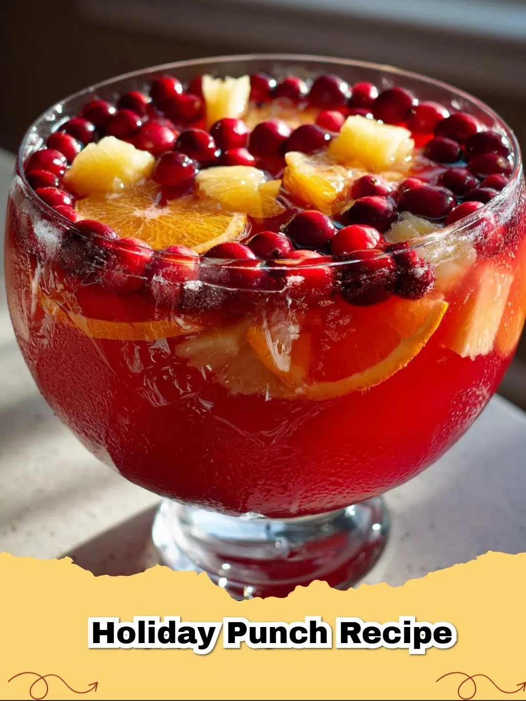 A sparkling holiday cranberry punch with fresh cranberries and orange slices in a glass punch bowl, perfect for festive gatherings.