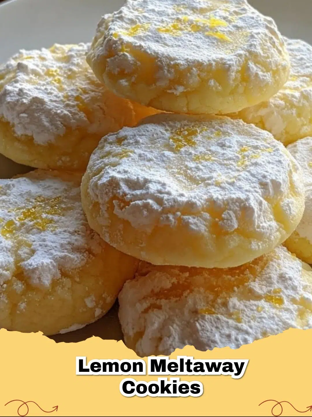 Pile of Easy Lemon Meltaway Cookies dusted with powdered sugar on a white plate with fresh lemons in the background