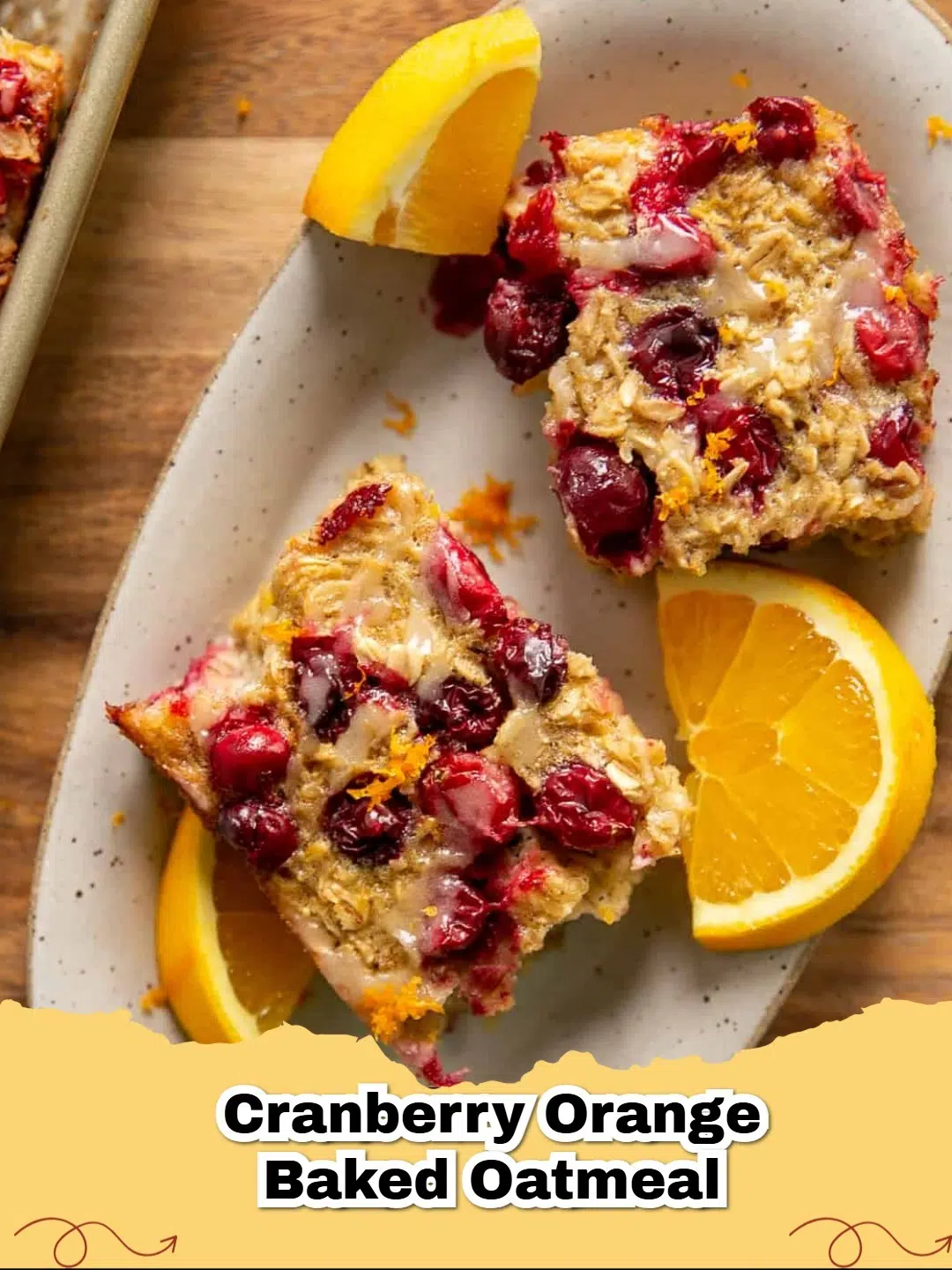 Close-up of baked gluten-free cranberry orange oatmeal with a light orange glaze on top, in a baking dish.