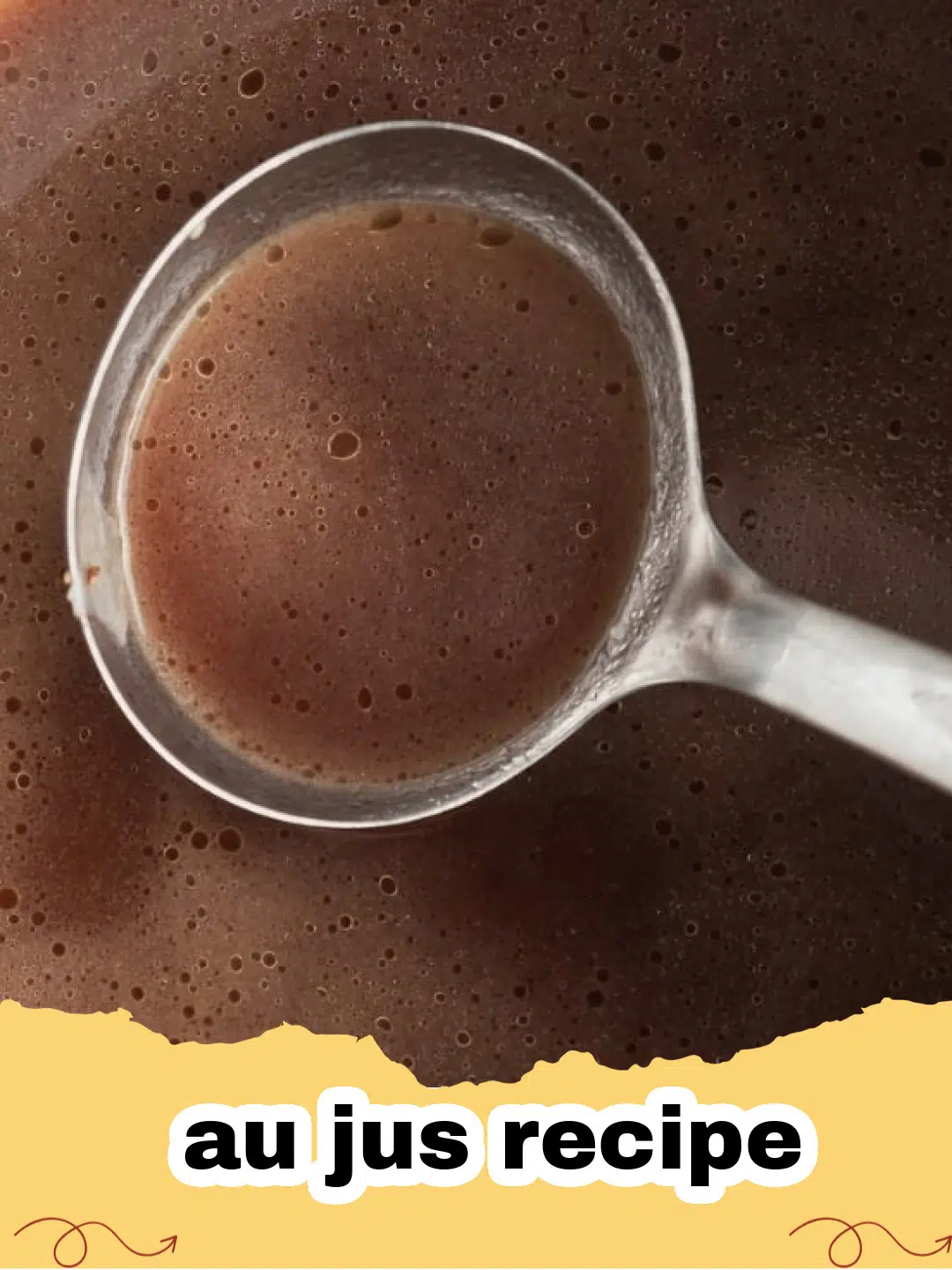 A bowl of rich, brown homemade au jus with a roast beef sandwich in the background, ready for dipping.