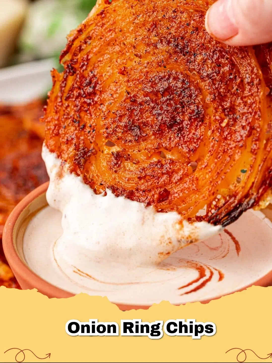 A pile of golden brown, crispy Keto Parmesan Onion Ring Chips on a white plate, garnished with fresh parsley.