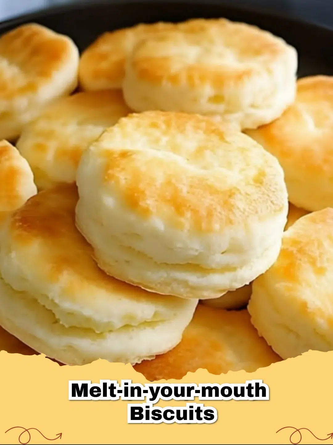 Fluffy, golden melt-in-your-mouth biscuits stacked on a cooling rack with butter.