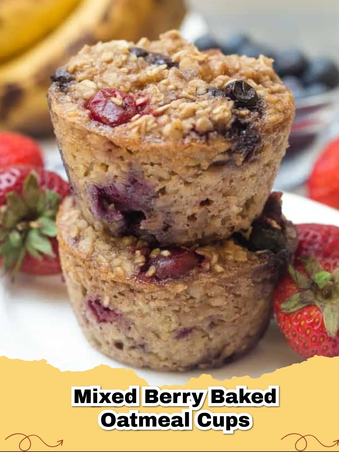 Close-up of freshly baked Mixed Berry Banana Baked Oatmeal Cups in a muffin tin, garnished with fresh berries.