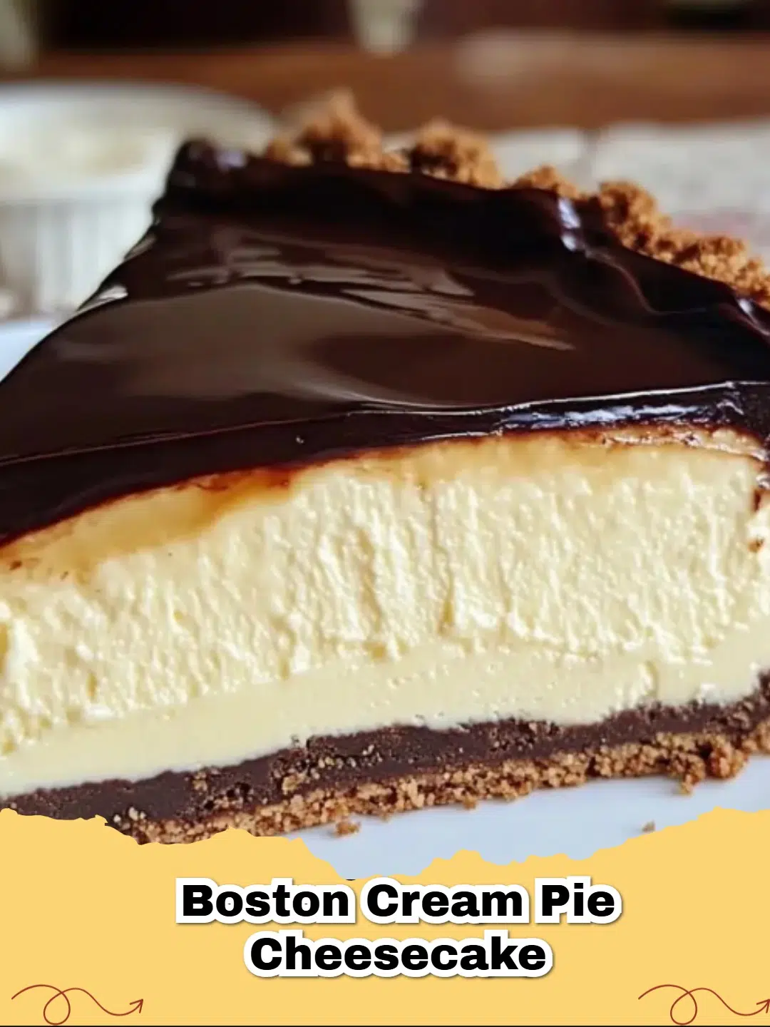 A thick slice of Boston Cream Pie Cheesecake showing layers of graham cracker crust, cheesecake, yellow custard, and chocolate ganache.