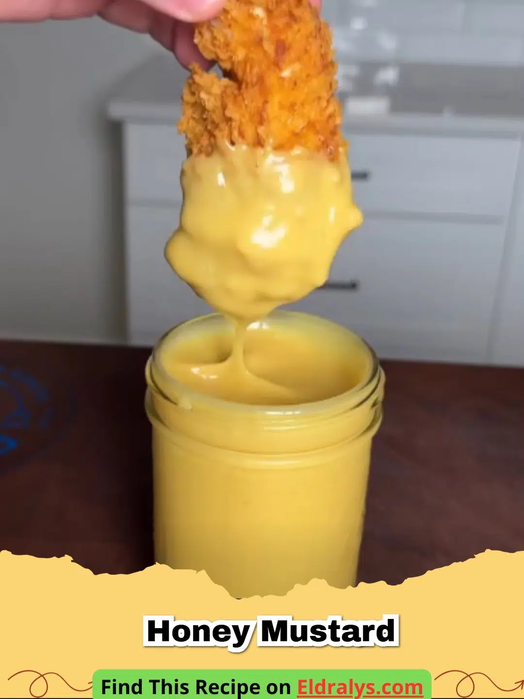 A small white bowl filled with creamy yellow Honey Mustard sauce with a honey dipper next to it.