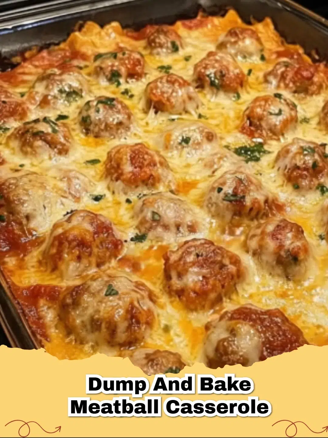 A bubbling Dump and Bake Cheesy Meatball Pasta Casserole fresh from the oven, topped with melted mozzarella and fresh herbs.