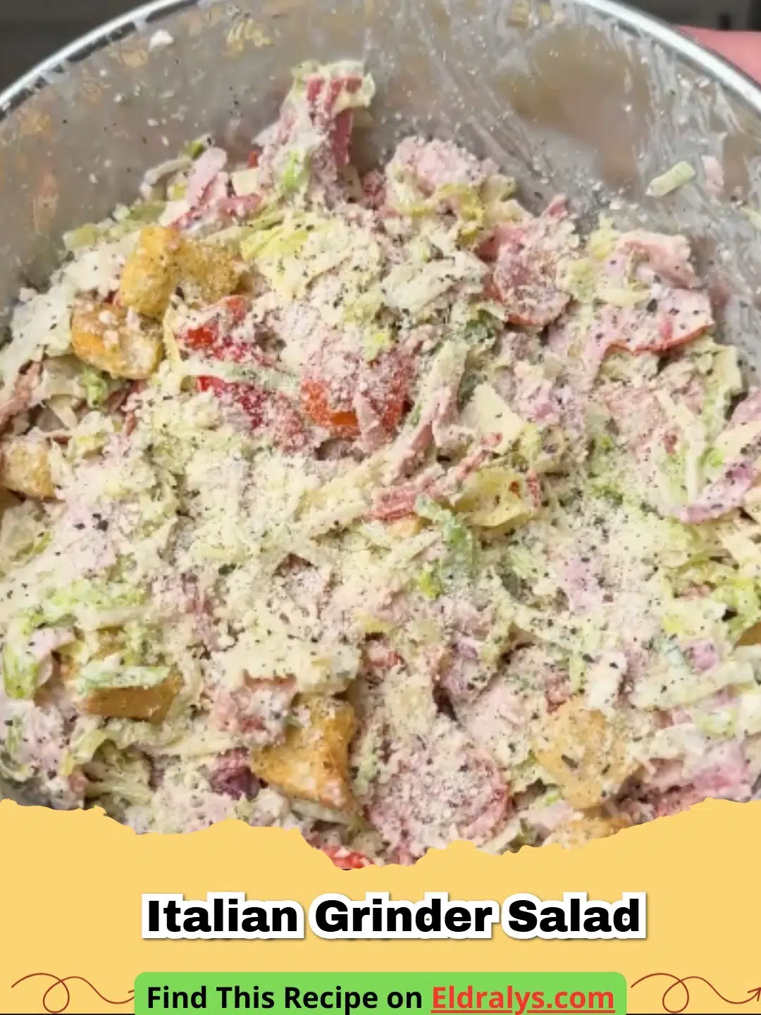 A close-up of a colorful Italian Grinder Salad with shredded lettuce, salami, and creamy dressing.