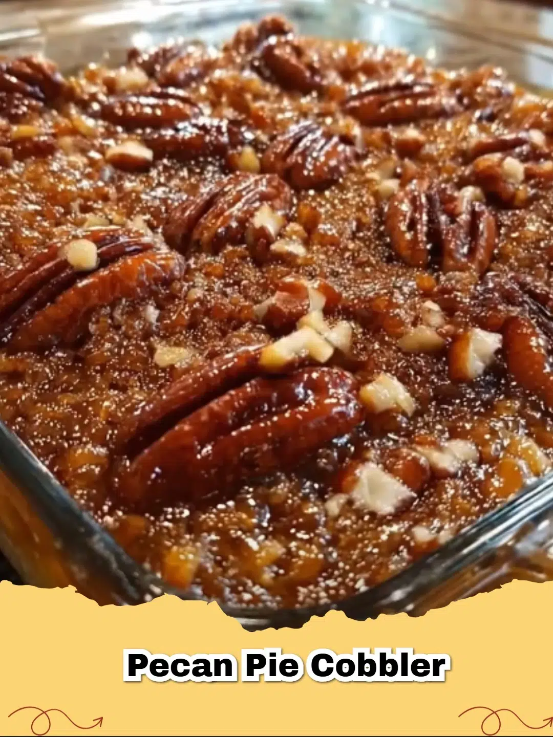 Close-up of a warm Pecan Pie Cobbler in a baking dish, with a scoop removed showing the gooey pecan filling and golden crust.