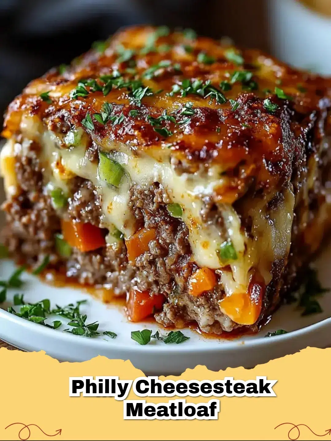 A thick slice of Philly Cheesesteak Meatloaf showing the melted provolone and pepper filling.