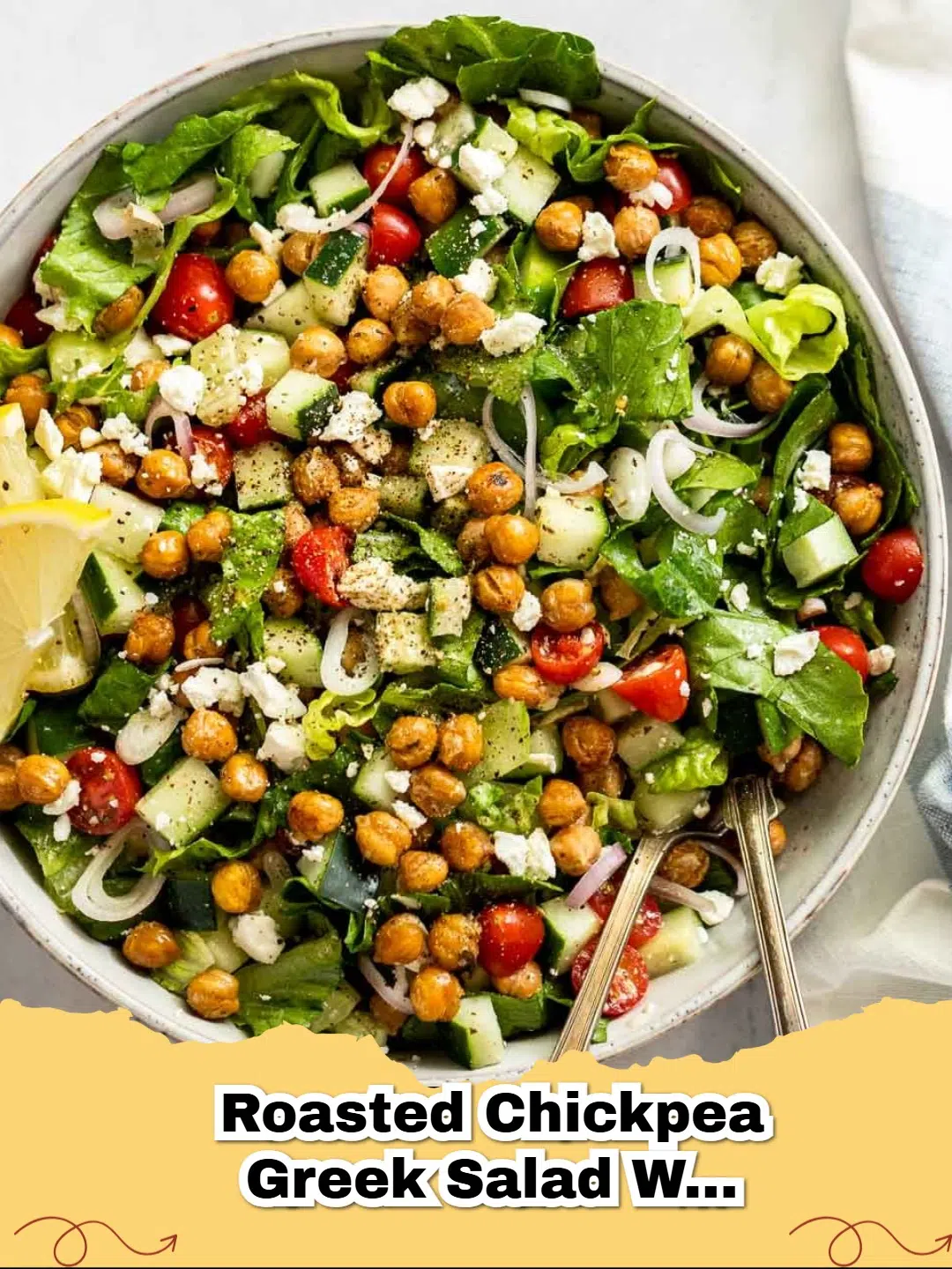 A vibrant bowl of Roasted Chickpea Greek Salad with Lemon-Herb Dressing with feta cheese