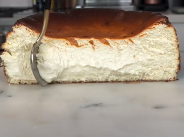 A close up of a San Sebastian Burnt Basque Cheesecake with its characteristic scorched top and creamy center.