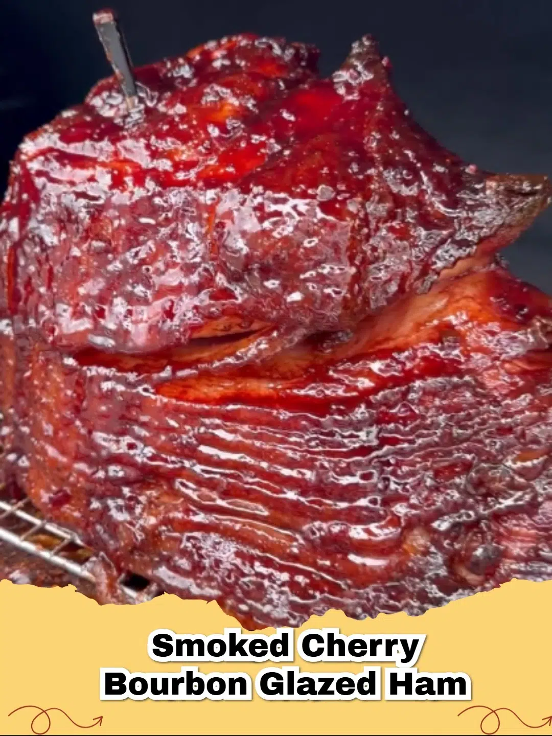 A beautifully glazed smoked cherry bourbon glazed ham on a serving platter garnished with rosemary.