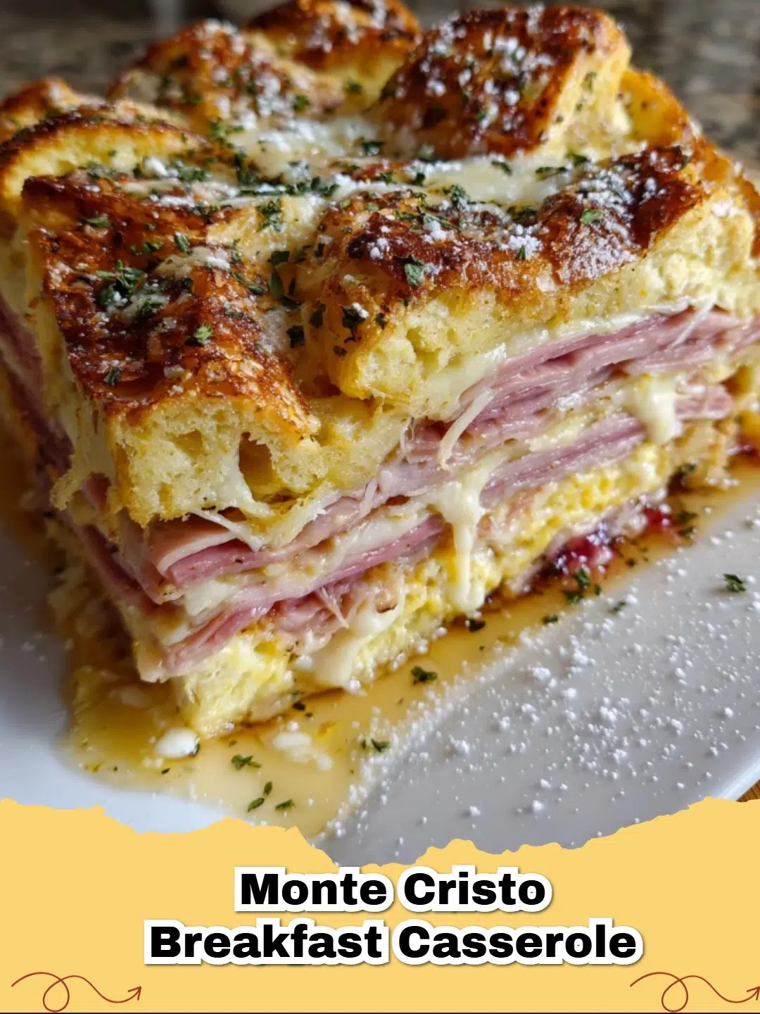 Delicious sweet and savory Monte Cristo breakfast casserole dusted with powdered sugar and served with raspberry jam.