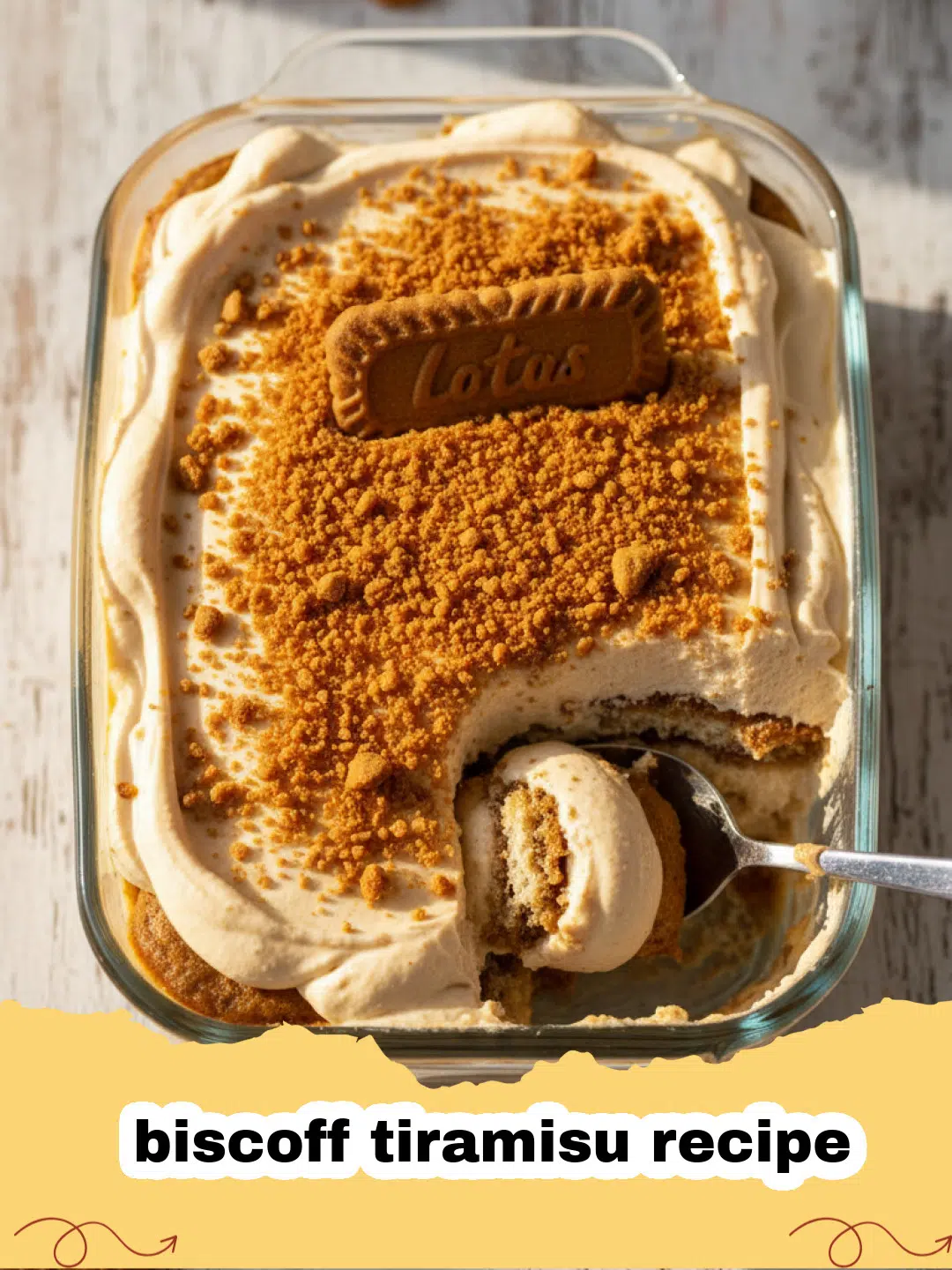 biscoff tiramisu recipe - A close-up of a layered Biscoff Tiramisu in a glass dish with cookie crumbs on top.