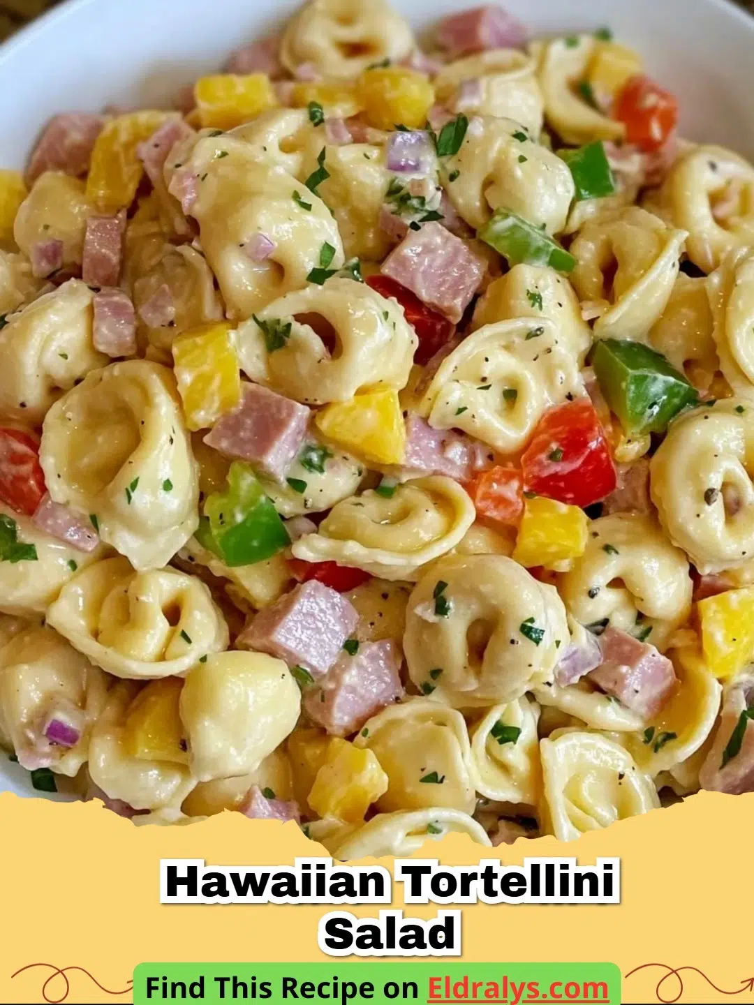 A large bowl of Hawaiian Tortellini Salad with pineapple and ham.