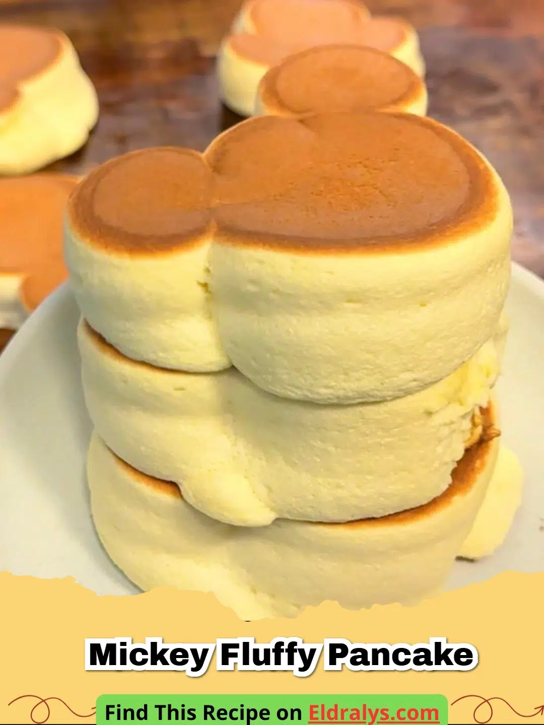 A stack of tall and jiggly Mickey Mouse Fluffy Japanese Soufflé Pancakes topped with berries.