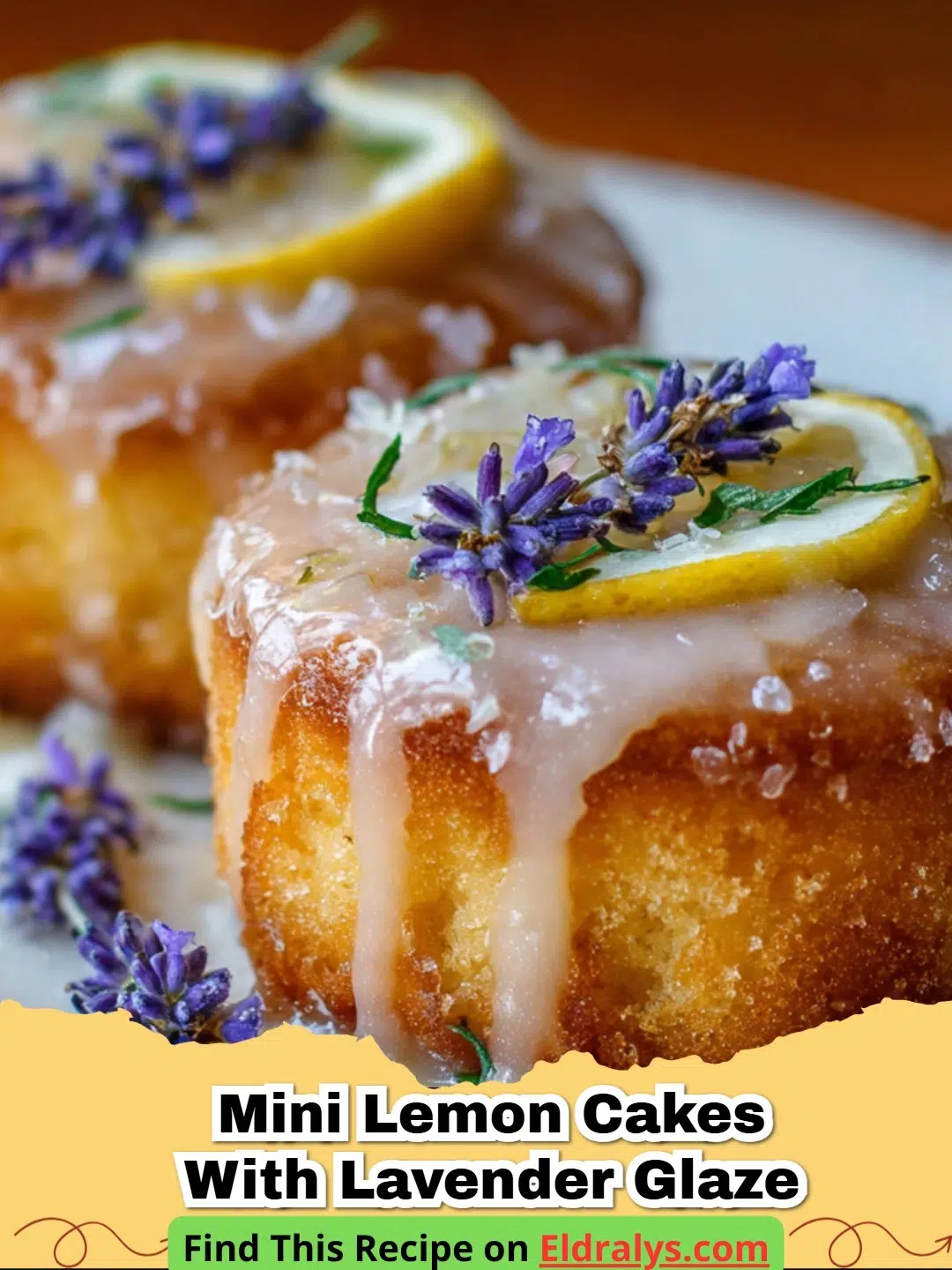 Beautiful Mini Lemon Cakes with Lavender Glaze on a white marble surface garnished with flowers.
