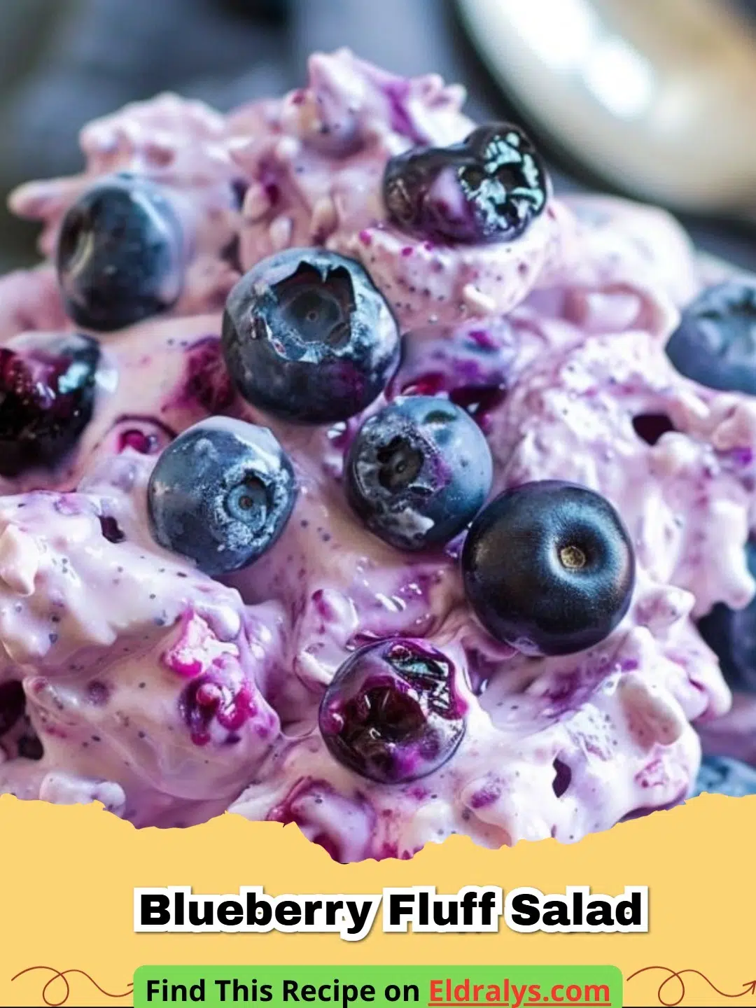A large glass bowl filled with vibrant purple Blueberry Fluff Salad topped with marshmallows.