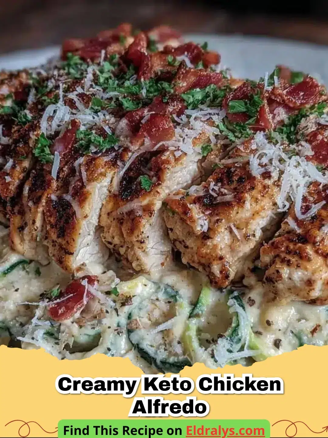 A close up shot of Creamy Keto Chicken Alfredo served in a black skillet with fresh parsley garnish.