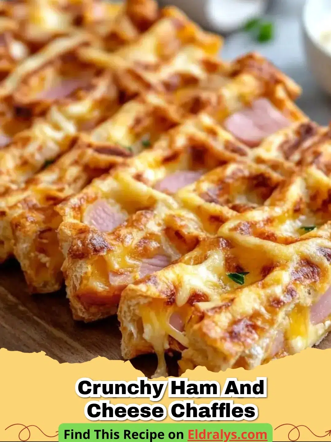 Two golden brown Crunchy Ham and Cheese Chaffles stacked on a plate with fresh chives.