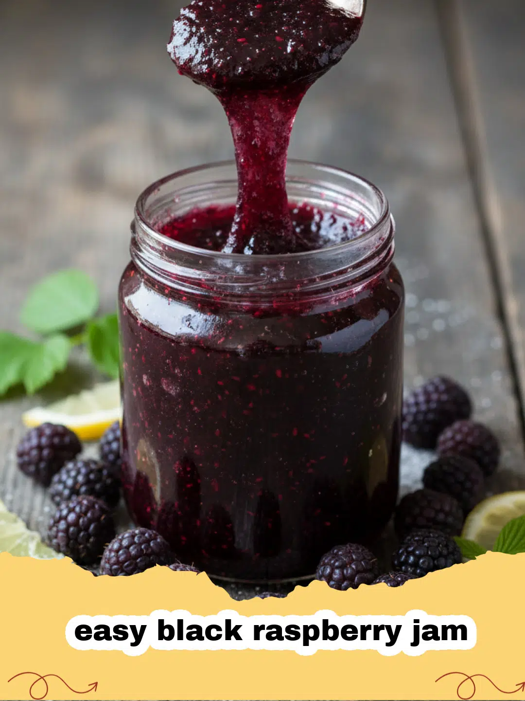 A close-up of a glass jar filled with deep purple easy black raspberry jam and a silver spoon.