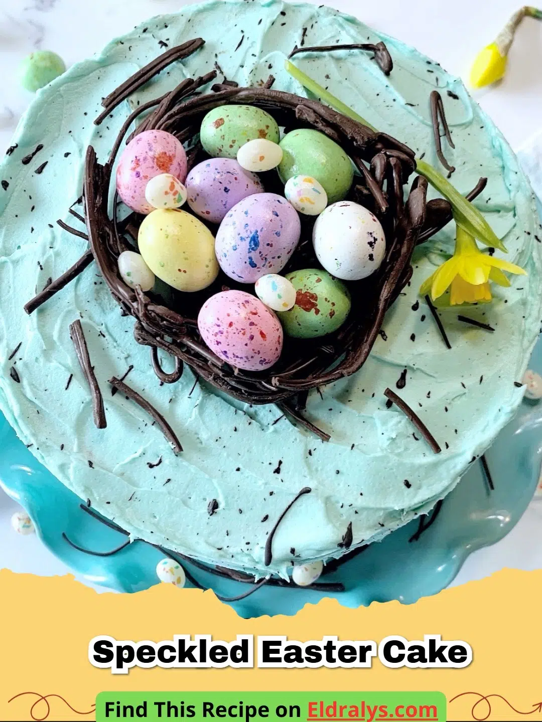A beautiful Speckled Easter Cake styled like a robin's egg with malted egg candies on top.