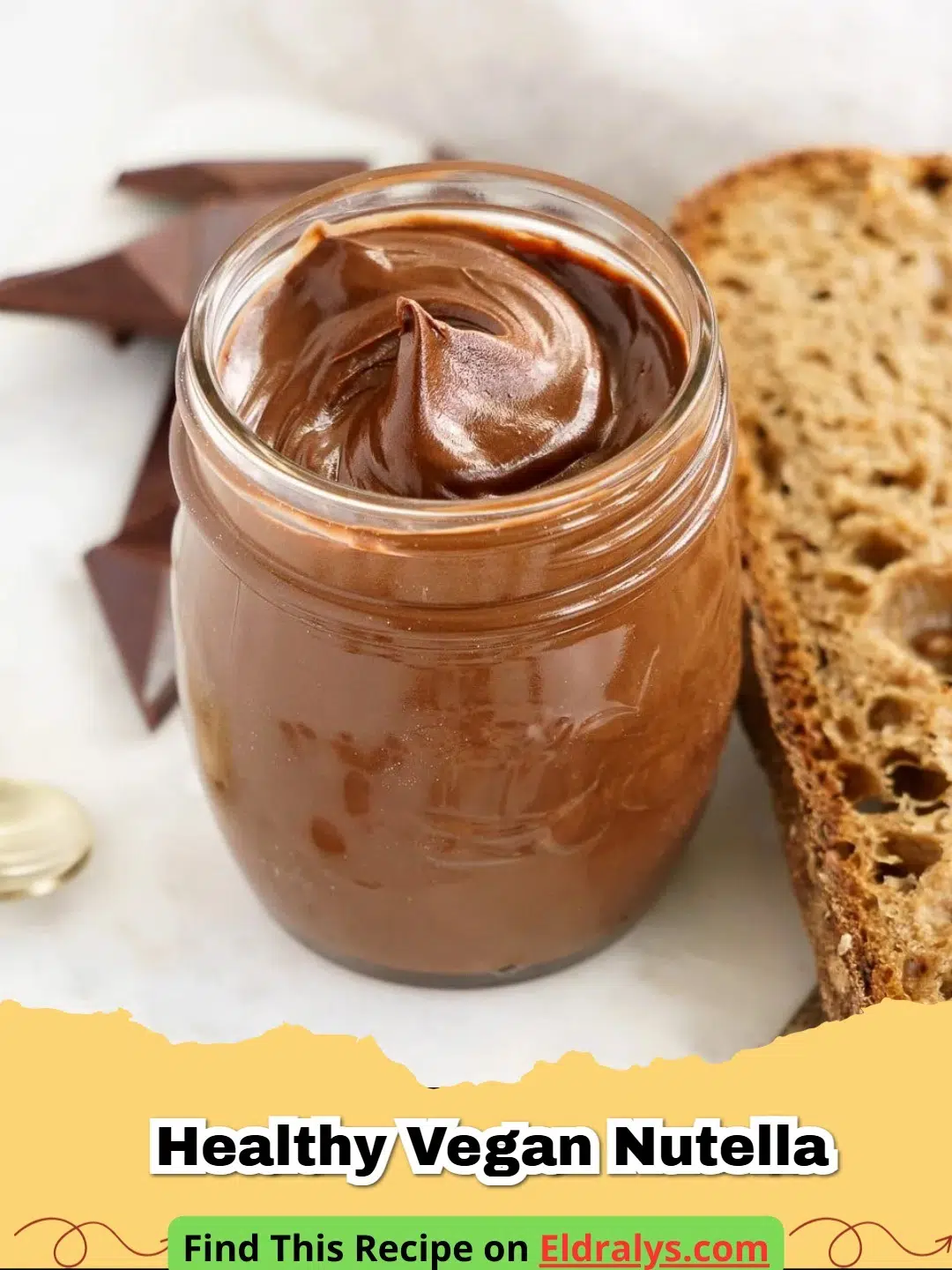 A jar of creamy Healthy Vegan Nutella with hazelnuts scattered around it.