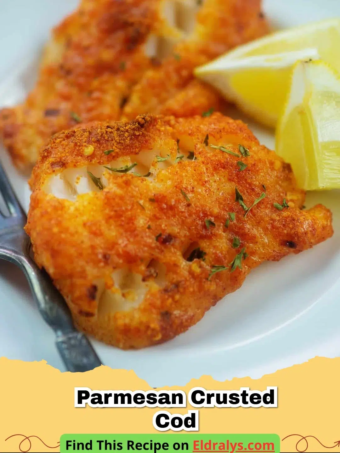 A close up of a golden-brown Parmesan Crusted Cod fillet on a white plate with lemon slices.