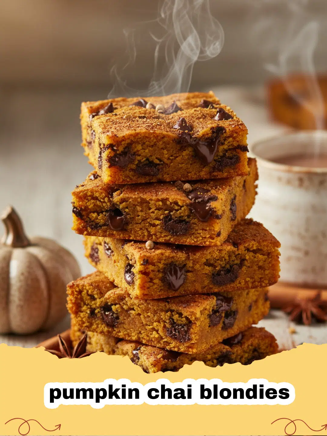 A stack of chewy pumpkin chai blondies on a wooden board with autumn leaves nearby.