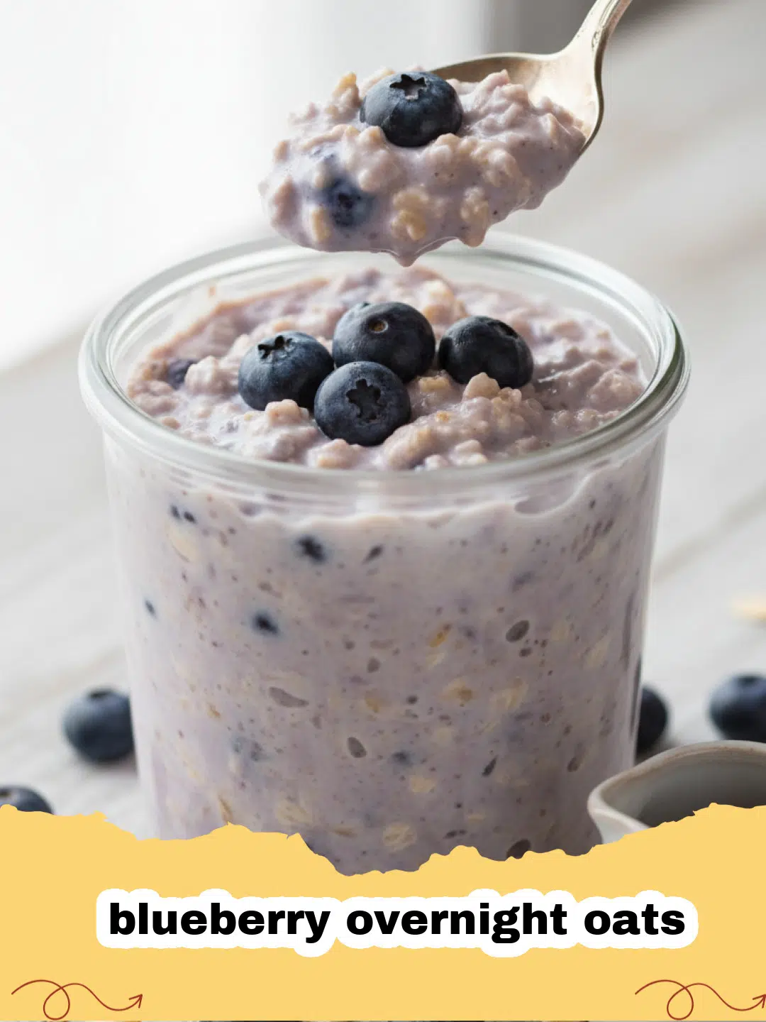 A close-up of a glass jar filled with creamy blueberry overnight oats, topped with fresh blueberries and a sprinkle of chia seeds.