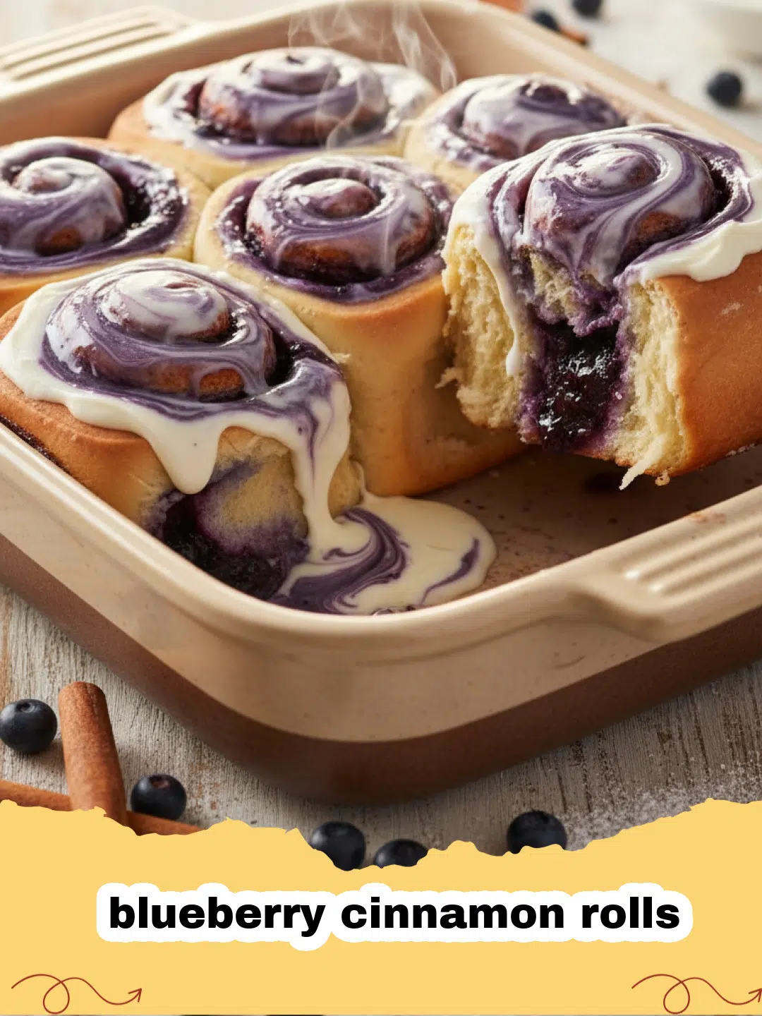 A tray of warm, glazed blueberry cinnamon rolls fresh from the oven, with some pulled apart to show the fluffy dough and juicy blueberry swirls.