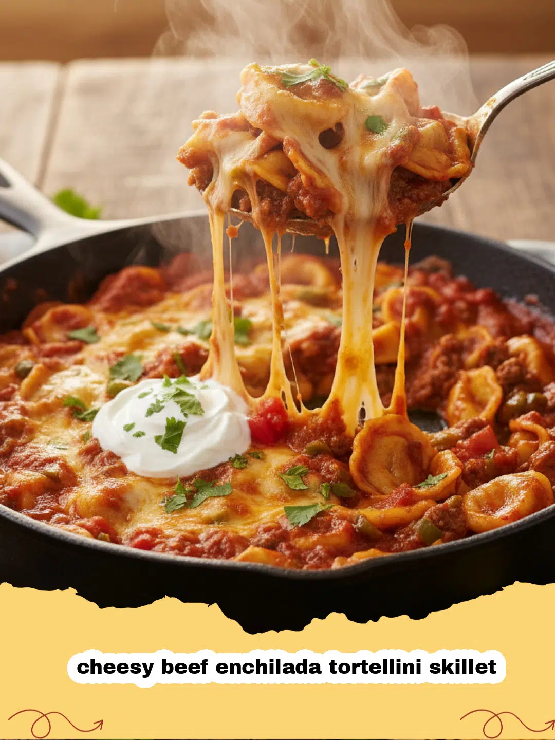 Close-up of a bubbling cheesy beef enchilada tortellini skillet garnished with fresh cilantro and a dollop of sour cream.