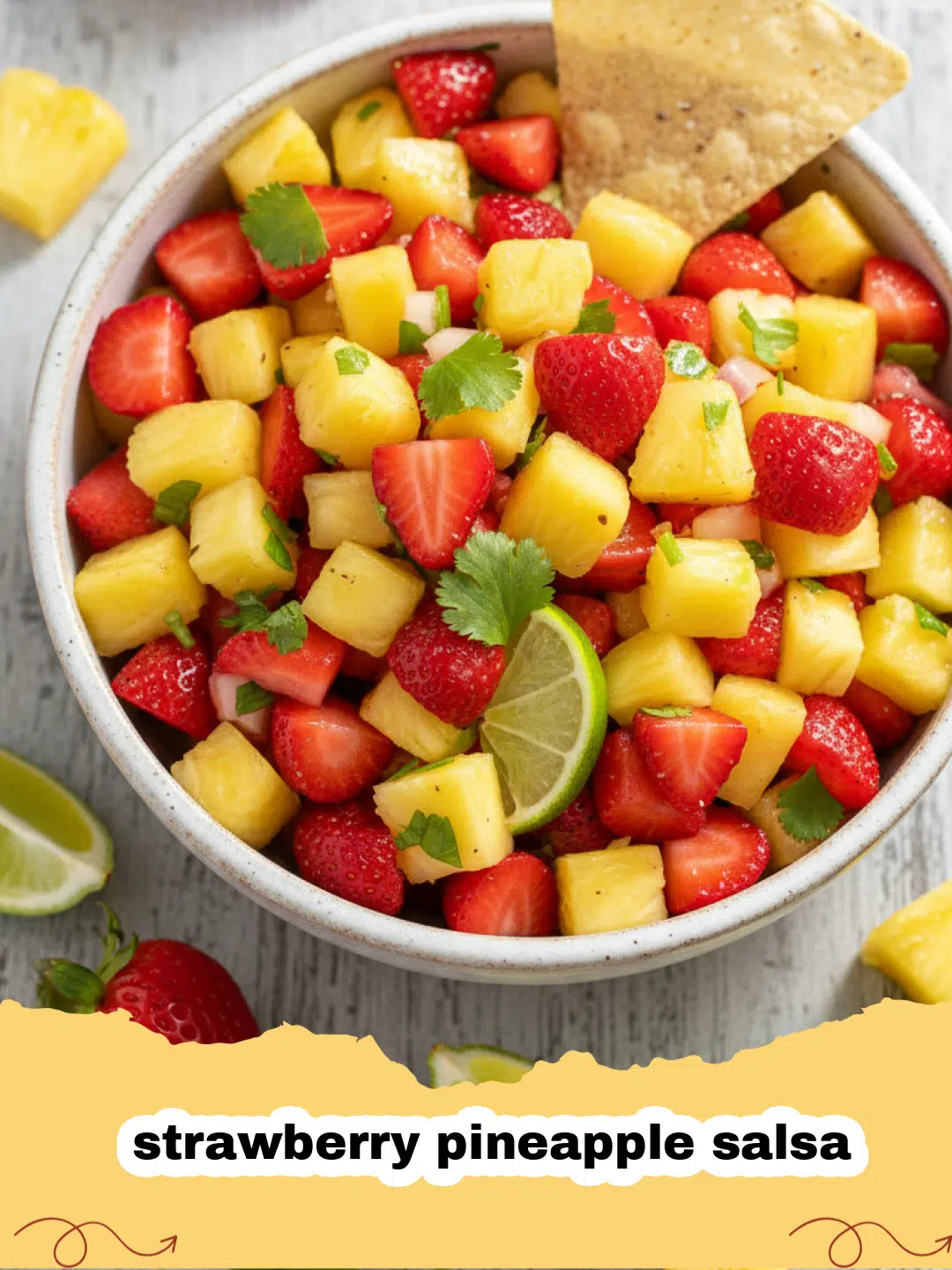 A vibrant bowl of fresh strawberry pineapple salsa with tortilla chips on the side.