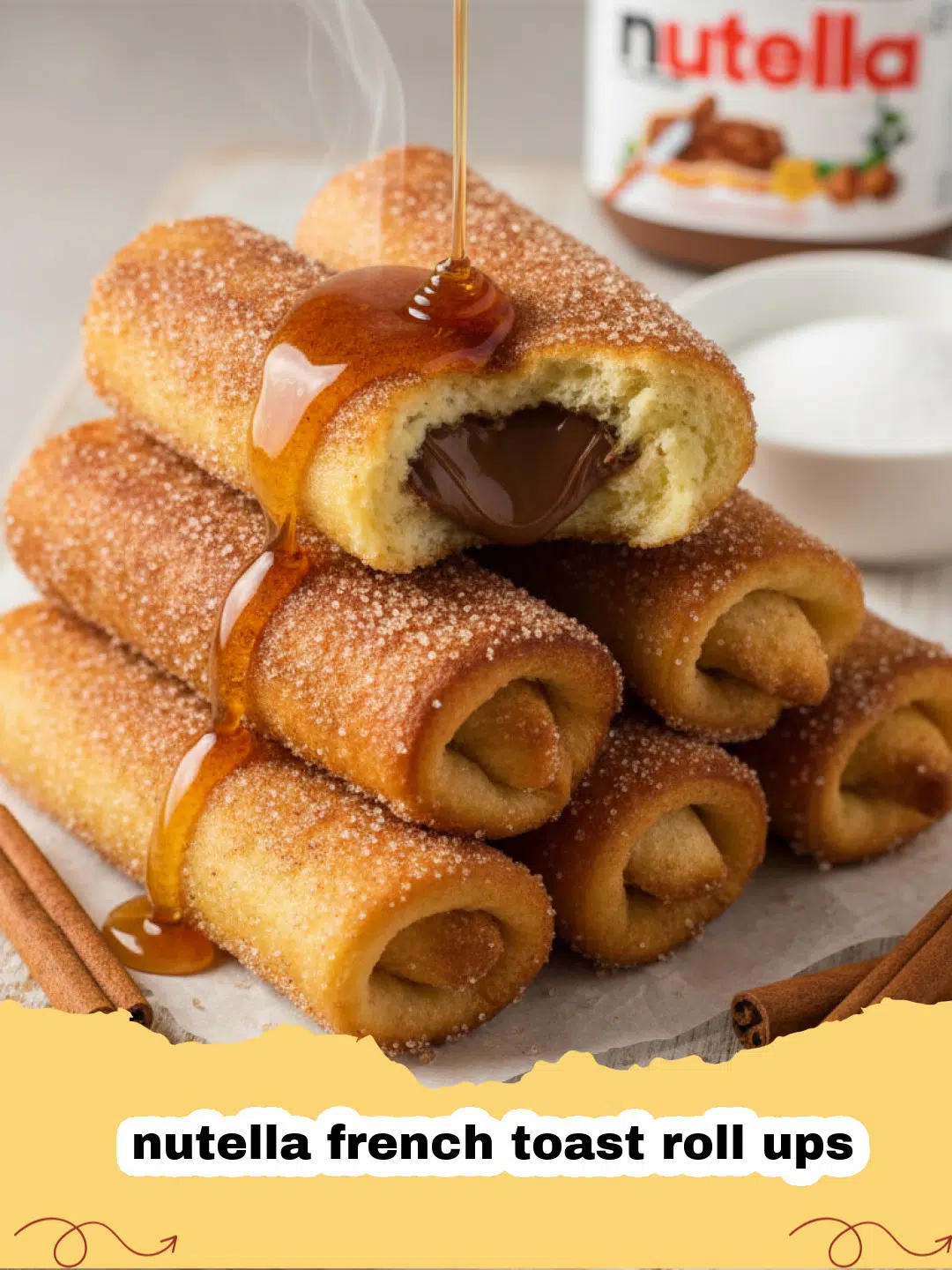 nutella french toast roll ups - Pile of golden brown Nutella French Toast Roll Ups coated in cinnamon sugar, with a small dish of Nutella and a sprig of mint in the background.