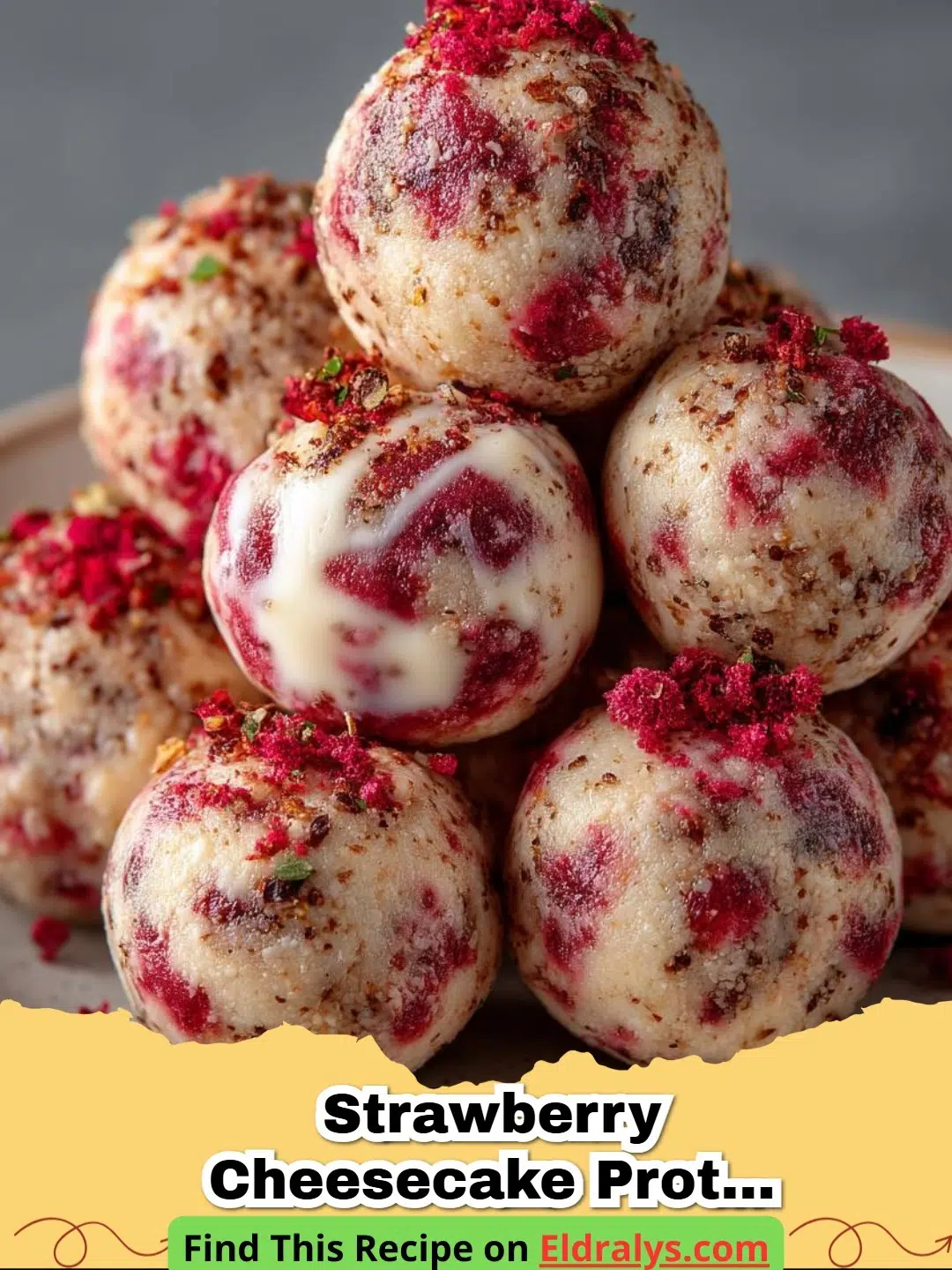 Close up of several No-Bake Strawberry Cheesecake Protein Balls on a white plate with fresh strawberries in the background.