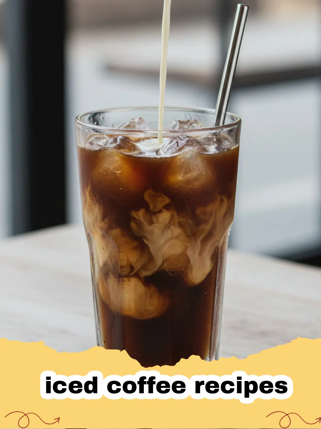iced coffee recipes - A tall glass of homemade iced coffee with ice, a splash of milk, and a straw, on a rustic wooden table.
