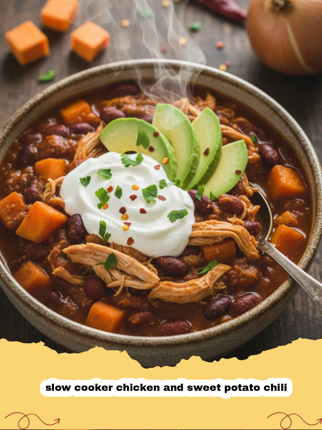 A steaming bowl of slow cooker chicken and sweet potato chili garnished with fresh cilantro and a dollop of sour cream.