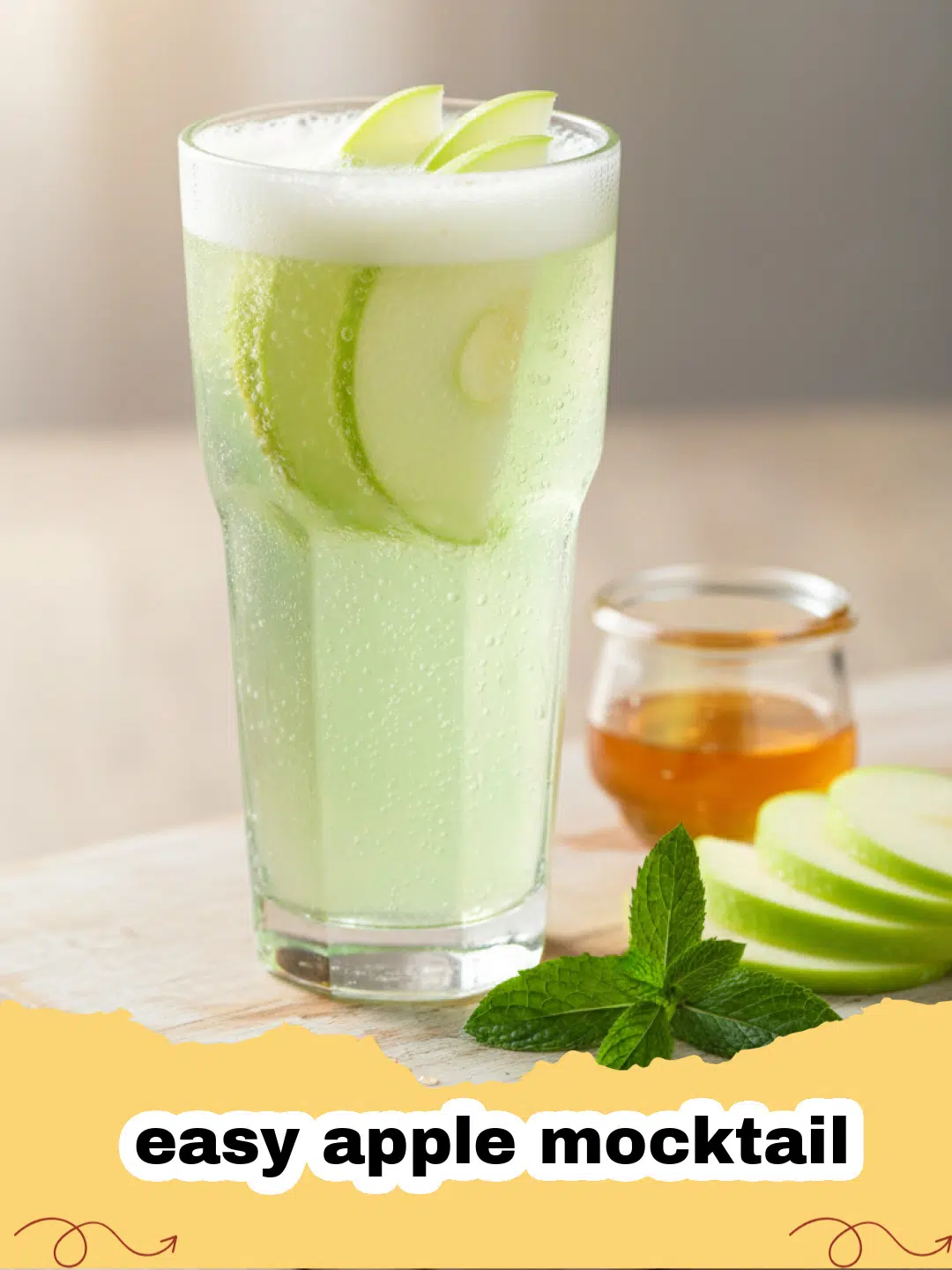 easy apple mocktail - Close up of a sparkling apple mocktail garnished with fresh apple slices and cinnamon sticks in a tall glass.