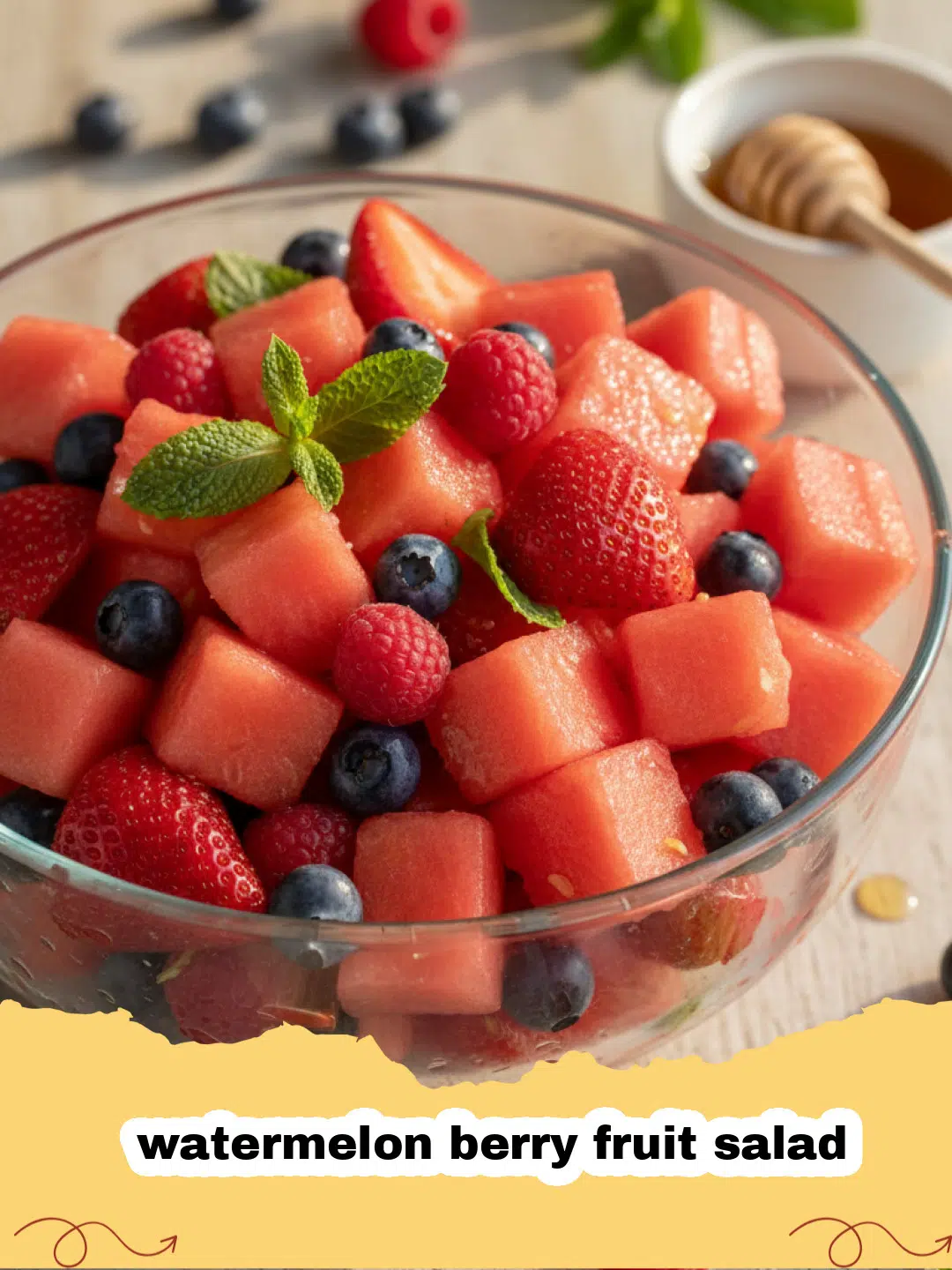 Close-up of a vibrant watermelon berry fruit salad in a large bowl, garnished with fresh mint leaves.