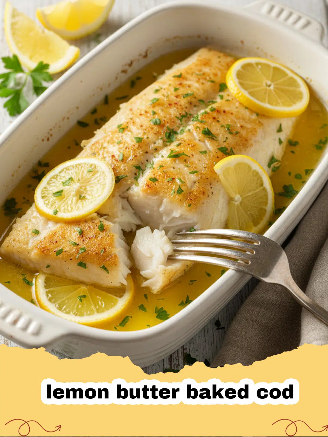 Flaky lemon butter baked cod fillets garnished with fresh dill and lemon slices on a white plate with roasted asparagus.