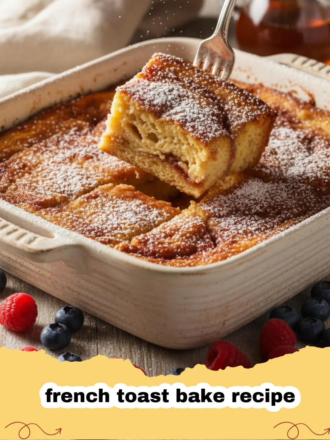 french toast bake recipe - Golden brown French toast bake recipe in a white ceramic baking dish, topped with powdered sugar and fresh berries.