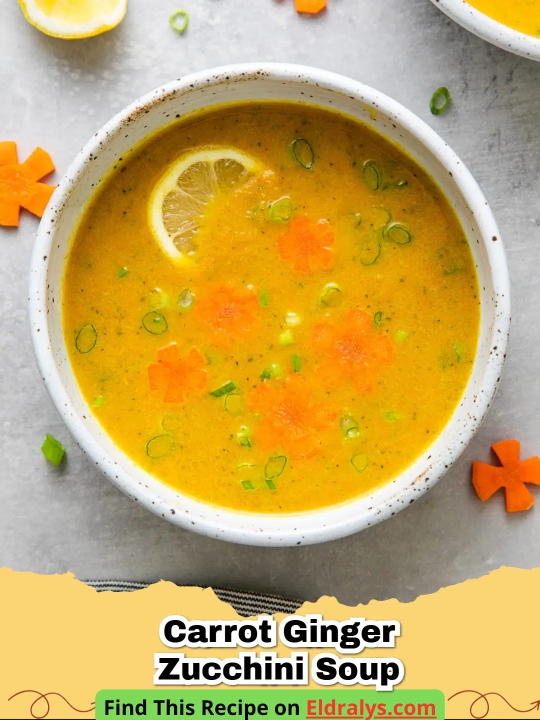 A steaming bowl of vibrant orange Carrot Ginger Zucchini Soup garnished with herbs.