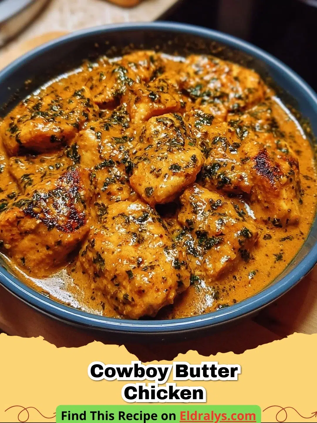 A close up of Cowboy Butter Chicken in a cast iron skillet surrounded by fresh herbs