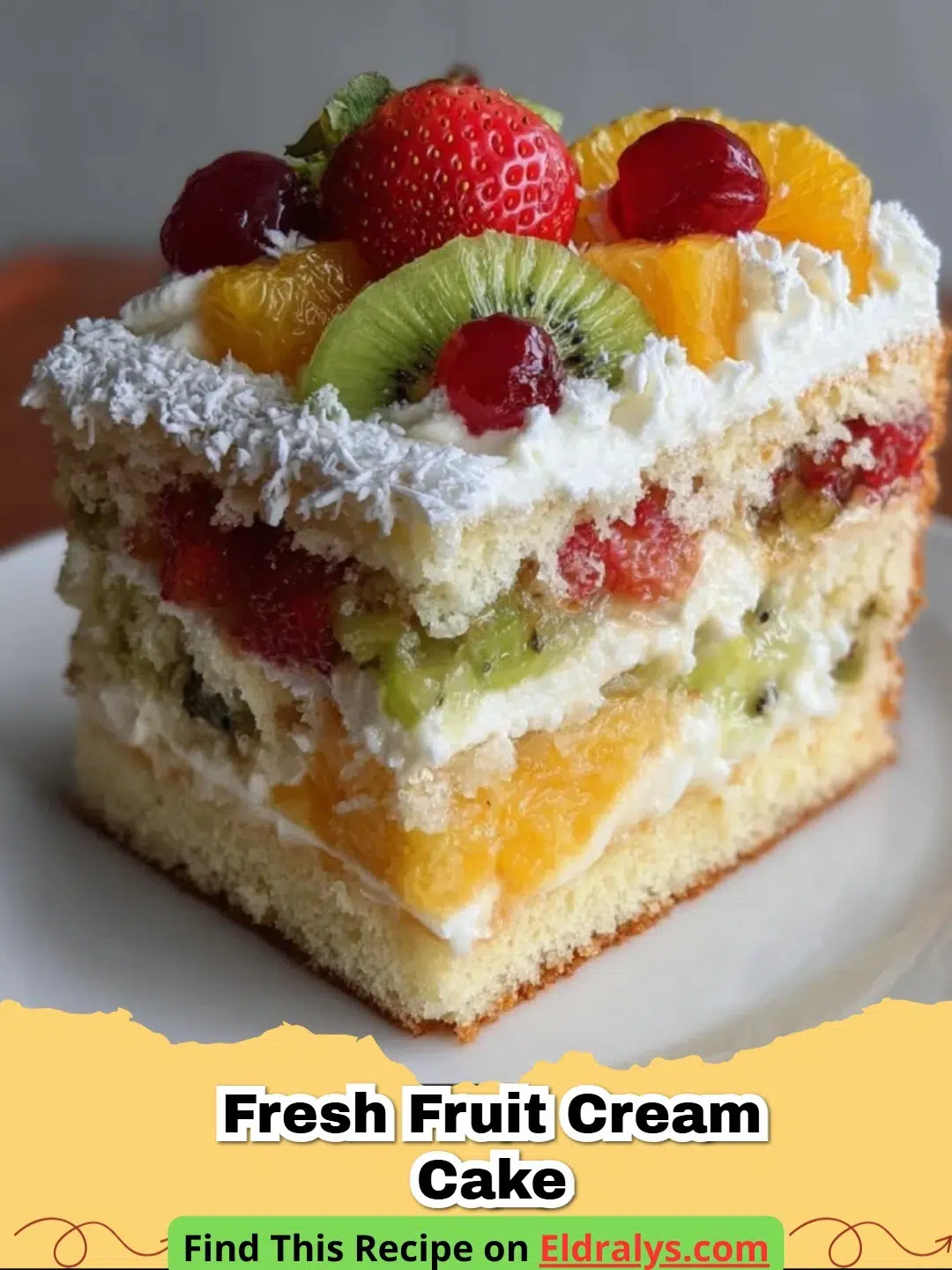 A beautiful Fresh Fruit Cream Cake topped with strawberries, blueberries, and kiwis on a white cake stand.